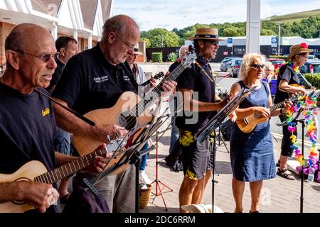 Eine Ukulele Band spielt Musik außerhalb des Tesco Supermarket zur Unterstützung der lokalen Foodbank, Lewes, East Sussex, UK. Stockfoto