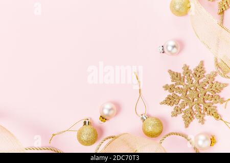 Weihnachtsfeiertage Komposition. Festliche kreative Gold-Muster, Weihnachten goldene Dekor Weihnachtskugel mit Band, Schneeflocken auf rosa Hintergrund. Stockfoto