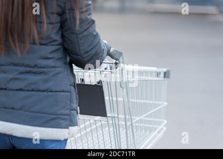 Frau schiebt einen leeren Warenkorb Stockfoto