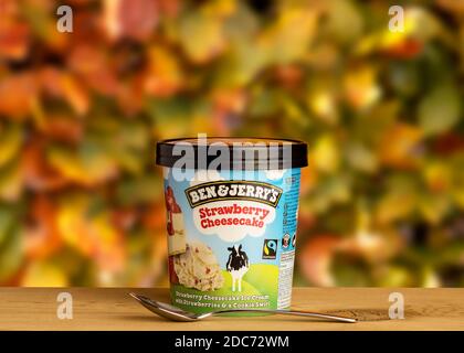 Ben & Jerry's Erdbeer Käsekuchen Eis auf dem Holztisch im Freien vor natürlichen Herbst verschwommen Hintergrund. Stockfoto