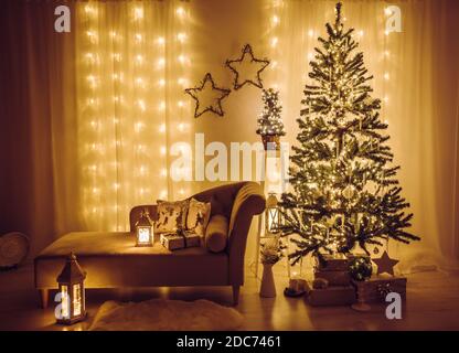 Heim Wohnzimmer für Heiligabend dekoriert. Weihnachtsfichte geschmückt mit Party-Lichter, Eiszapfen und Schneeflocken, eingewickelte Weihnachtsgeschenke. Stockfoto