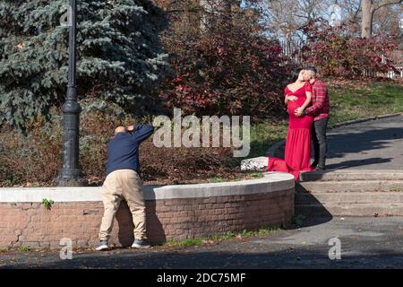 Ein Ehemann und eine schwangere Frau beauftragen ein Fotoshooting anlässlich ihrer Schwangerschaft. An einem milden Herbsttag in Queens, New York City. Stockfoto
