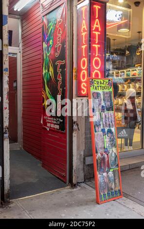 Der Eingang zu VERRÜCKTEN TATTOOS, ein Tattoo & Piercing Shop vertikal auf der Roosevelt Avenue in Jackson Heights, Queens, New York City. Stockfoto