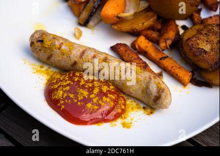 Vegane Currywurst mit Kartoffel- und Süßkartoffel-Split, Ketchup mit Currypulver gesund zu essen Stockfoto