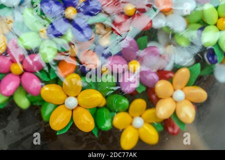 Zellophan Blatt verwischt mehrfarbige Bündel von Zucker überzogenen Mandelblüten, traditionelle historische Stadt süße Spezialität, in hellem Licht in Sulmona aufgenommen Stockfoto