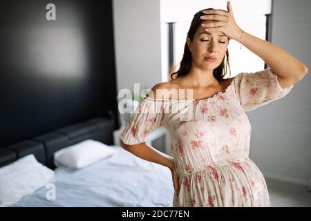 Schmerzen in der Schwangerschaft. Deprimiert schwangere Frau die Hand auf den Kopf Stockfoto