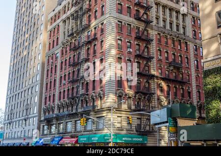 Typisches Manhattan Gebäude mit Feuertreppen und vielen Geschäften im Erdgeschoss. New York City, USA Stockfoto