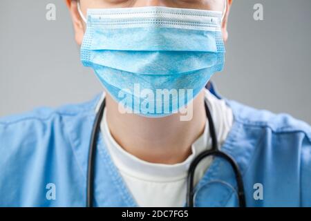 Nahaufnahme des Arztes in blauer Uniform mit blauer Schutzmaske, COVID-19 Coronavirus-Krankheit, globaler Pandemieausbruch, tödlicher Wuhan SARS-CoV-2 Stockfoto