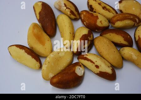 Hell und lecker, braun und weiß Brasilianer (Bertholletia excelsa) sind auf einem matten weißen Hintergrund angeordnet. Gesunde und gesunde Lebensmittel. Stockfoto