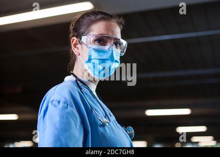 Junge weibliche UK NHS Arzt im Labor oder Krankenhaus Klinik, besorgt Und ängstlich, müde und erschöpft nach langen Schichten, Coronavirus COVID-19 Pandemiekrise Ca Stockfoto