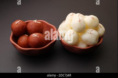 Berühmte indische Desserts wie Rasgulla/ rosogulla/ roshogulla und Gulab jamun/ Gulabjam werden in einer irdenen Schüssel serviert. Stockfoto