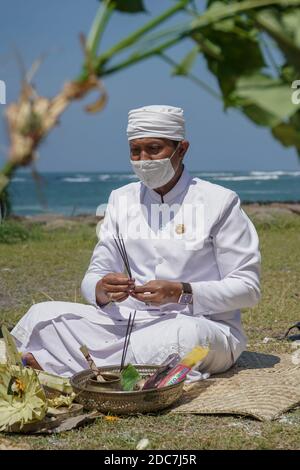 Badung, Bali, Indonesien. November 2020. Ein Bali-Hindu-Religionsführer betet vor der Zeremonie. ''Ngaben Bikul'' oder Ratten-Einäscherungszeremonie, die am Seseh-Strand als Reinigungszeremonie abgehalten wird, um Rattenpest für die nächste landwirtschaftliche Pflanzsaison zu verhindern. Mehr als 250 Ratten haben nach 107 Hektar 9.593 Hektar Reis-Agrarland von der Rattenpest betroffen eingeäschert und machte schlechte Ergebnis der Erntezeit in Badung Regentschaft in diesem Jahr. (Bild: © Dicky BisinglasiZUMA Wire) Stockfoto