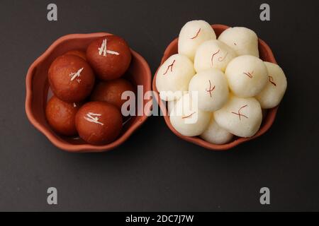 Berühmte indische Desserts wie Rasgulla/ rosogulla/ roshogulla und Gulab jamun/ Gulabjam werden in einer irdenen Schüssel serviert. Stockfoto