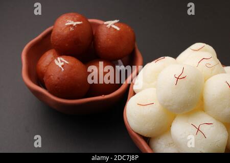 Berühmte indische Desserts wie Rasgulla/ rosogulla/ roshogulla und Gulab jamun/ Gulabjam werden in einer irdenen Schüssel serviert. Stockfoto
