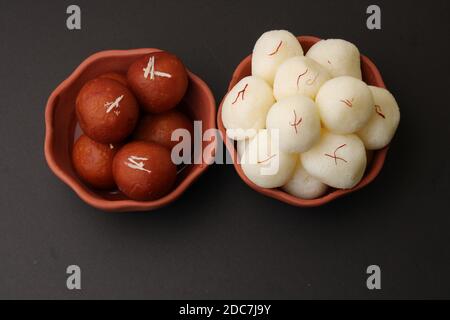 Berühmte indische Desserts wie Rasgulla/ rosogulla/ roshogulla und Gulab jamun/ Gulabjam werden in einer irdenen Schüssel serviert. Stockfoto