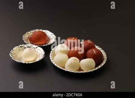 Berühmte indische Desserts wie Rasgulla/ rosogulla/ roshogulla und Gulab jamun/ Gulabjam werden in Silberteller/ Schüssel serviert. Stockfoto