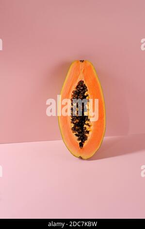 Kreatives Layout aus Papaya. Die Hälfte der reifen Papaya mit Schatten auf dem Hintergrund. Food-Konzept. Sommerhintergrund. Stockfoto
