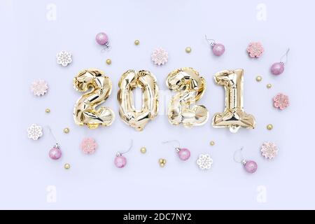 Foliengolden Ballons in Form von Zahlen 2021 und festliche Dekorationen auf hellem Hintergrund. Neujahr. Feiertagsdekoration. Stockfoto