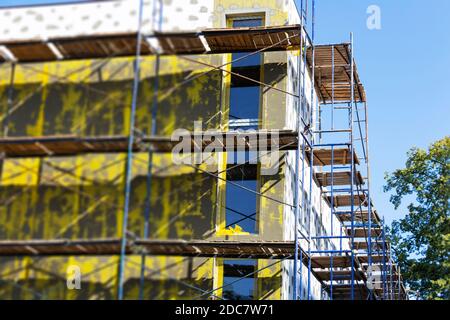 Isolierung von Wänden, Installation von Gerüsten, Hochhaus Arbeit, Energieeinsparung. Stockfoto