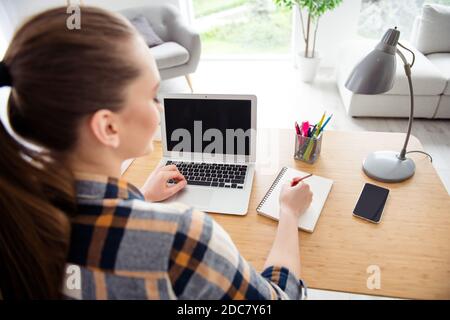 Zurück hinten abgeschnitten Ansicht Foto von jungen Teenager Dame Schule Mädchen Student Laptop Notebook Desktop Video Anruf hören Lehrer Lektion Online notieren Copybook Stockfoto