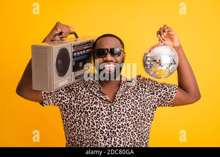 Foto von verrückten lustigen kühlen dunklen Haut Kerl halten Retro Tape Recorder Glitter Disco Ball Freude Sommer Strand Party tragen leopardenhemd Sonnenbrille Stockfoto