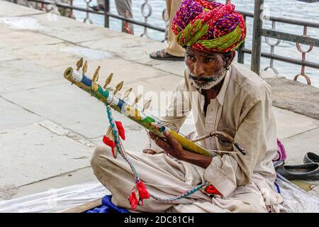 Der arme Musiker/Straßenkünstler am Straßenrand, der ein traditionelles Instrument spielt Von Rajasthan genannt ravanhatha Stockfoto