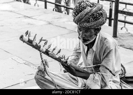 Der arme Musiker/Straßenkünstler am Straßenrand, der ein traditionelles Instrument spielt Von Rajasthan genannt ravanhatha Stockfoto