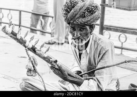 Der arme Musiker/Straßenkünstler am Straßenrand, der ein traditionelles Instrument spielt Von Rajasthan genannt ravanhatha Stockfoto