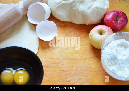 Home Herbst, Sommer Backen, Blätterteiggebäck. Apfelstrudel mit Nüssen, Rosinen, Zimt und Puderzucker. Auf Holztisch. In Scheiben geschnitten, mit Zutaten. C Stockfoto