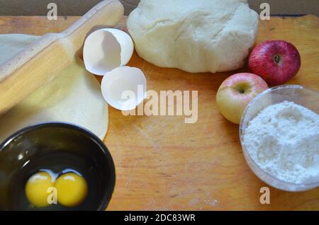 Home Herbst, Sommer Backen, Blätterteiggebäck. Apfelstrudel mit Nüssen, Rosinen, Zimt und Puderzucker. Auf Holztisch. In Scheiben geschnitten, mit Zutaten. C Stockfoto