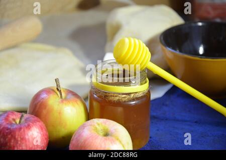 Verschiedene Zutaten für das winterliche Backen und andere Rezepte, Honig, Äpfel, Kräuter und Gewürze auf dunkelblauem Hintergrund. Draufsicht. Stockfoto