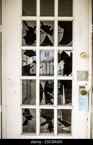 Nahaufnahme eines zerbrochenen Glases in einer getäfelten Tür eines Verlassenes Haus Stockfoto