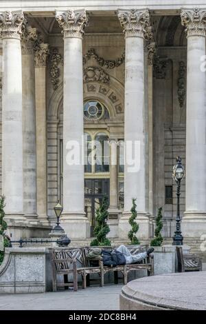 Rauer Schläfer auf einer Bank vor der Royal Exchange in der City of London. Stockfoto