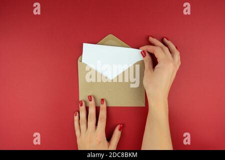 Eine Frau hält einen Brief in einem Umschlag in sich Hände Stockfoto