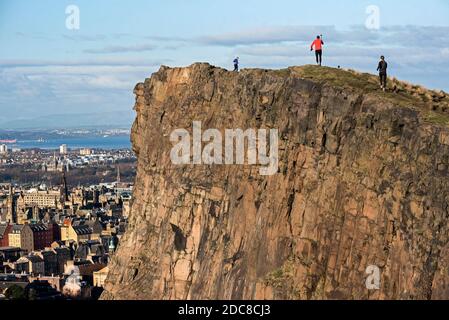 Läufer, die die November-Sonne auf den Salisbury Crags genießen, Edinburgh, Schottland, Großbritannien. Stockfoto