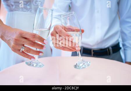 Schöne Hochzeitsgläser in den Händen der Braut und des Bräutigams Stockfoto