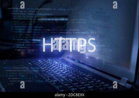 HTTPS-Inschrift gegen Laptop und Code-Hintergrund. Internet-Sicherheitskonzept. Stockfoto