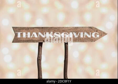 Thanksgiving Holzpfeil Straßenschild gegen Bokeh Hintergrund. Stockfoto