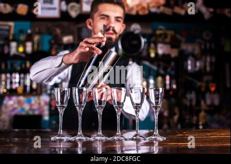 Bartender beendet seine Kreation intensiv an der Bar Stockfoto