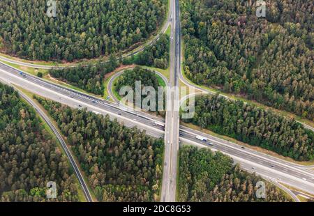 Luftaufnahme der Autobahnkreuzung mit dem Autoverkehr. Draufsicht aus der Vogelperspektive auf das Bild der Kreuzung im Wald Stockfoto