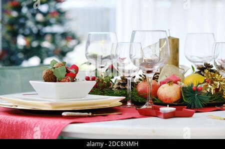 Weihnachtsessen und Neujahrsfeier Konzept. Nahaufnahme Dekoration auf dem Tisch bereit für Quest Empfang, verzierte Tisch Einstellung mit Kerze und xm Stockfoto