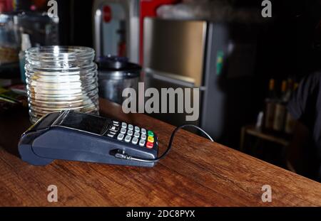 Das Zahlungsterminal für Kreditkarten befindet sich auf dem Tisch im Café des Cafés. Nahaufnahme des kontaktlosen Bezahlgeräts, des Kartenautomaten Stockfoto