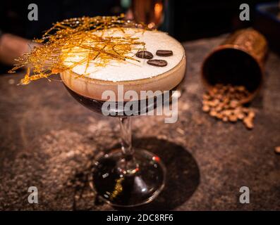 Espresso martini, mit Kaffeebohnen im Hintergrund Stockfoto