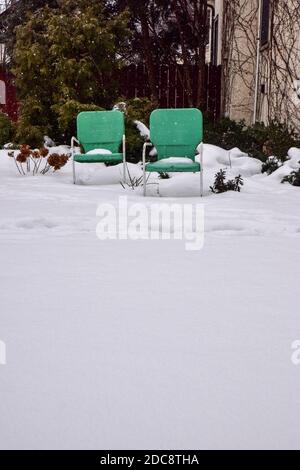 Grüne Outdoor-Stühle im Schnee zu Weihnachten Stockfoto