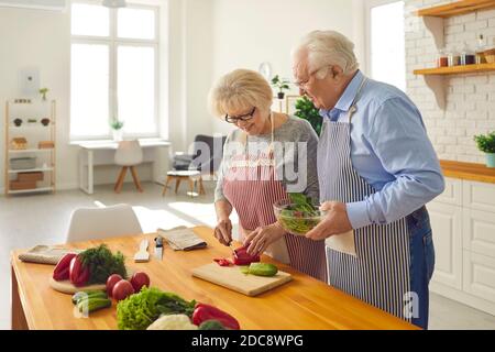 Glückliches Seniorenpaar kochen gesunden Salat zusammen zu Hause Stockfoto