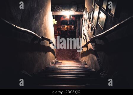 Dramatische Sicht auf die unheimlich Treppen von oben in die Dunkelheit des Inneren des alten Pubs Stockfoto