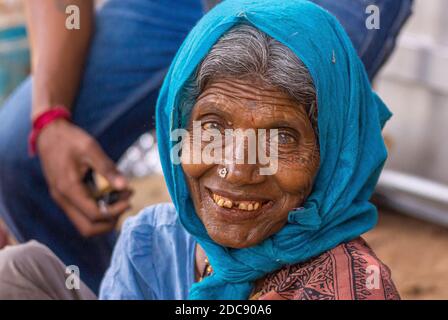 Chikkanayakanahalli, Karnataka, Indien - 3. November 2013: Nahaufnahme Porträt einer älteren lächelnden Frau mit blauem Schal. Stockfoto