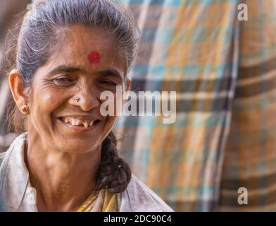 Chikkanayakanahalli, Karnataka, Indien - 3. November 2013: Nahaufnahme Porträt einer älteren lächelnden Frau mit grauen Haaren und schiefen Zähnen. Stockfoto