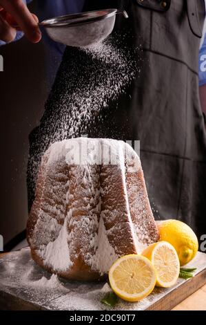 Mann Gießen mit Puderzucker Weiche sternförmige Pasta. Traditionelles italienisches Gebäck aus Verona zu Weihnachten mit Zitrone und Vanille. Süßer Kuchen für den Urlaub Stockfoto