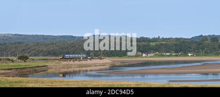 Nördliche Bahn CAF Klasse 195 Civity Zug vorbei Arnside, Cumbria läuft vor dem Viadukt spiegelt sich im Fluss Kent Stockfoto